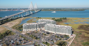 Aerial view of Tides condos in Mount Pleasant, SC showing all 3 buildings surrounded by the Arthur Ravenel Jr bridge, marshlands and Tide's parking lots.