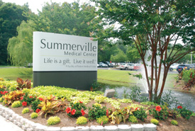 Summerville Medical Center's entrance sign by fountain and flowerbed.